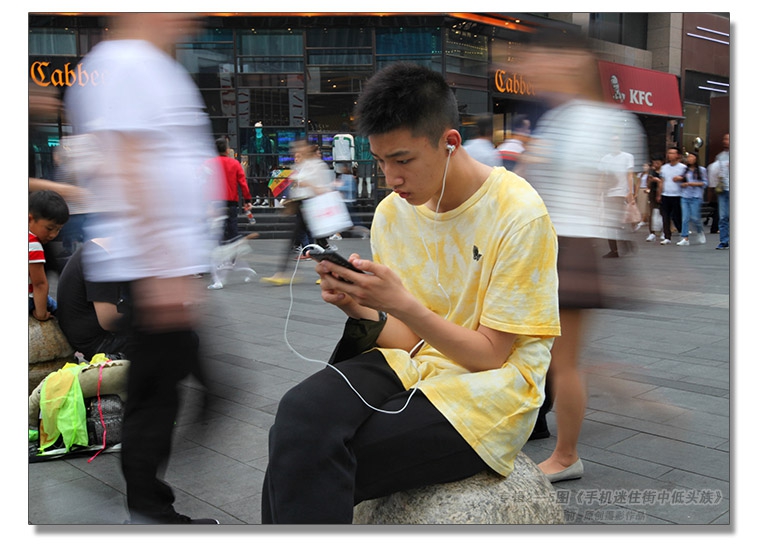 2018-5-27--玩手机专辑2--5图-3《手机迷住街中低头族》--支箭-用杆撑相机-反手抓拍于.jpg