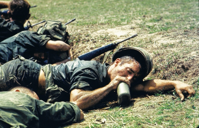 US infantryman, overcome by heat, drinki